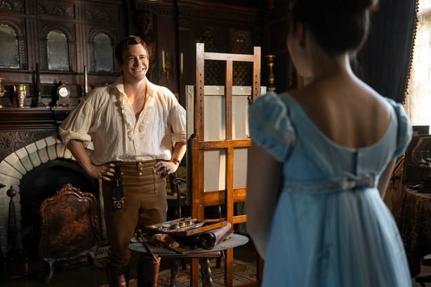 A male and female character talking in a scene from Bridgerton