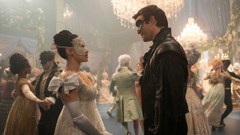 A male and female character speaking at a masquerade ball in a scene from Bridgerton