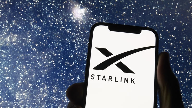 The Starlink logo appears on a smartphone screen with a starry night sky in the background