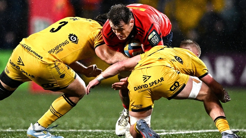 Brian Gleeson of Munster is tackled by Rob Hunt, left, and Harry Beddall of Dragons - URC, January 2026