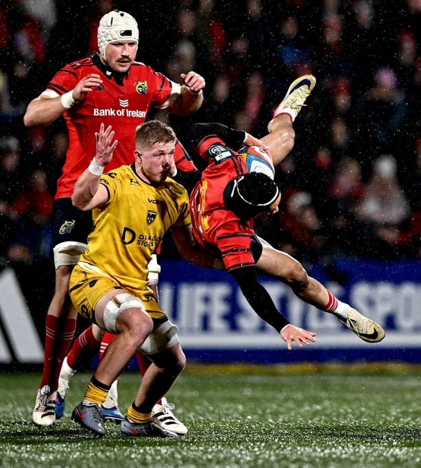 23 January 2026; Thaakir Abrahams of Munster gathers possession of the ball despite the tackle of Harry Beddall of Dragons during the United Rugby Championship match between Munster and Dragons at Virgin Media Park in Cork. Photo by Ben McShane/Sportsfile