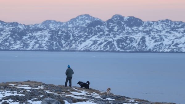 NUUK, GREENLAND - JANUARY 23: A man walks his dogs while looking over a fjord two days after U.S. President Donald Trump walked back on his most aggressive threats over acquiring Greenland on January 23, 2026 in Nuuk, Greenland. In his speech at the World
