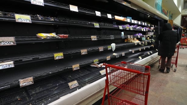 People shop at a supermarket as shelves are left empty in New York City ahead of the storm.