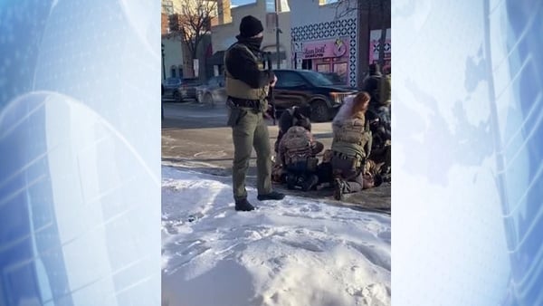 US immigration agents with guns on top of a man on the street