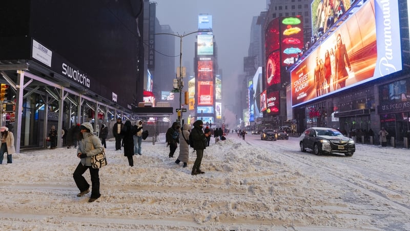 People walk through snowing conditions in New York's Times Square