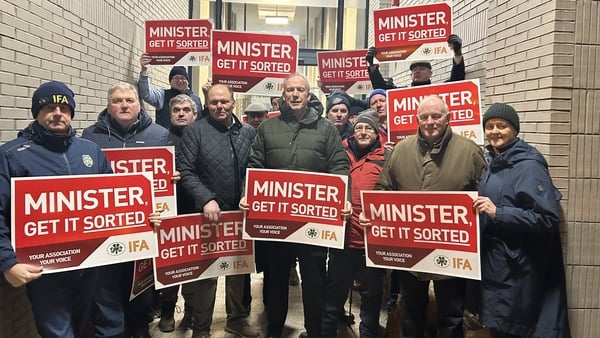 Men with placards protest outside an office