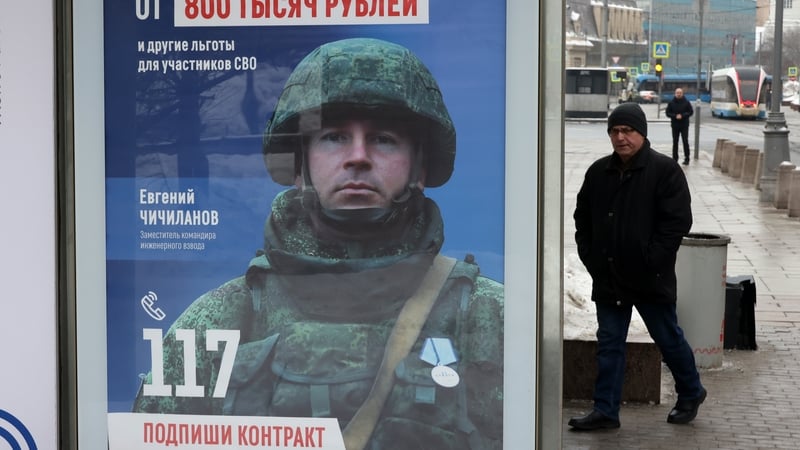 A pedestrian in Moscow passing an advertisement promoting contracts in the Russian army