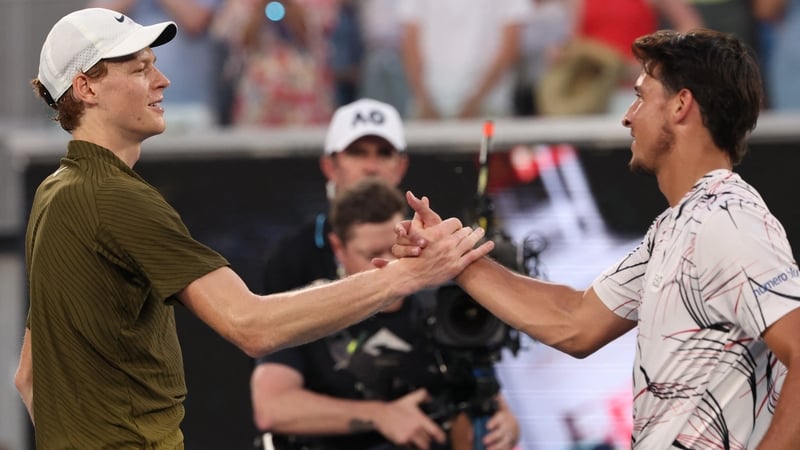 Jannik Sinner and compatriot Luciano Darderi shake hands after the defending champion's win in straight sets