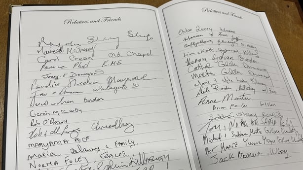 An open book shows the names of people paying tribute