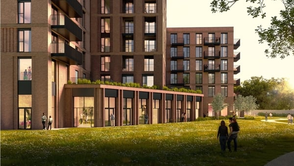 Green area with two people in the foreground of new proposed red brick apartments