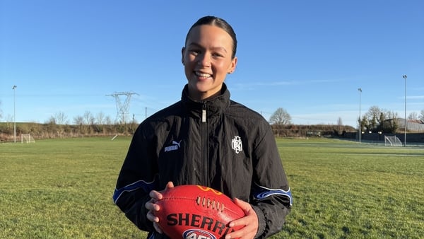 Amy Gavin Mangan holds an AFL ball at her local GAA pitch