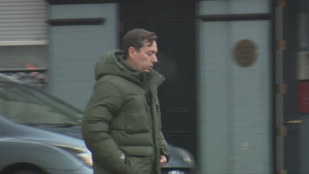 Middle-aged man walking in dark green Canada Goose puffer jacket outside the CCJ