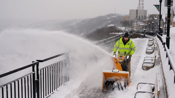 A Pittsburgh Public Works employee snow blows a sidewalk in the Mount Washington neighborhood of Pittsburgh, Pennsylvania, US, on Monday morning, Jan. 26, 2026. US power grids are expected to grapple with unprecedented seasonal demand and the threat of blackouts after a damaging winter storm coated 