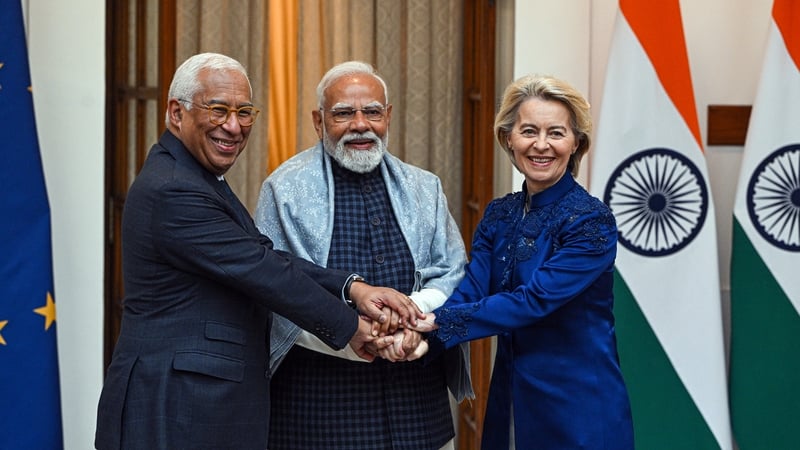 Photo shows two men and a woman clasping hands