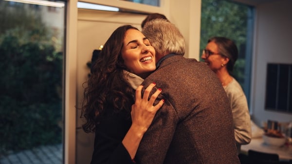 greeting and welcoming visiting family at front door.