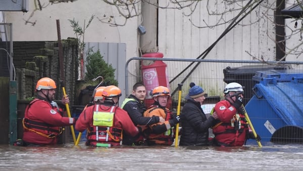 People are escorted through flood waters in Enniscorthy