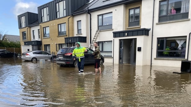 A man is taken through the floods at Cookstown Lane development