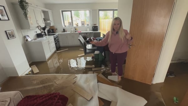 Amy Cullen in her flooded kitchen with floodwater visible all over the ground