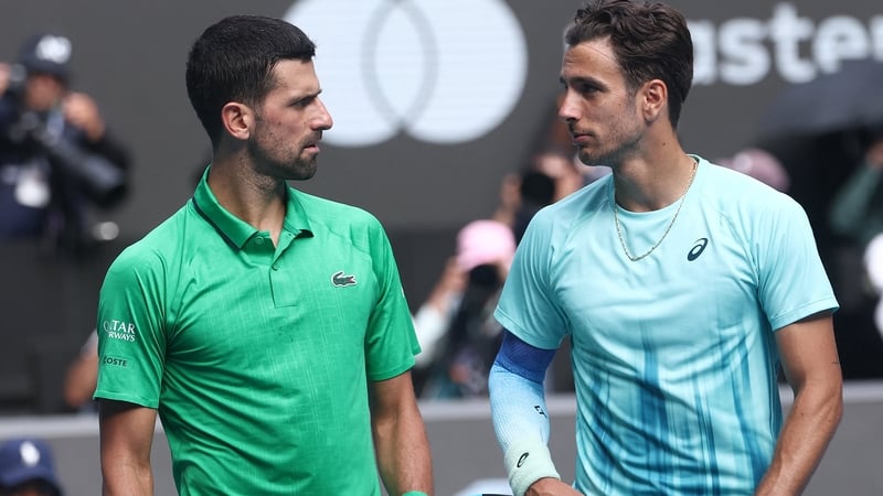 Italy’s Lorenzo Musetti (R) walks off the court with Serbia’s Novak Djokovic