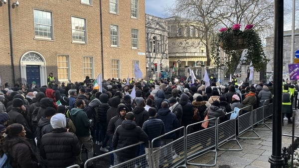 hundreds of people are seen at a protest