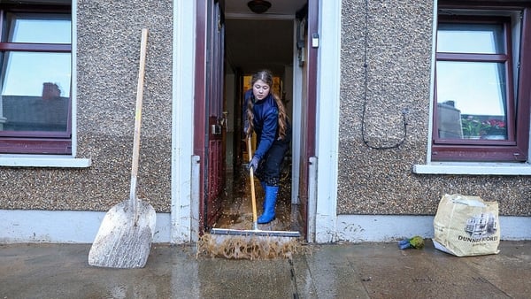 A person clears flood water from a house