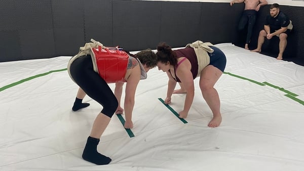 Two people take part in sumo wrestling in Ireland