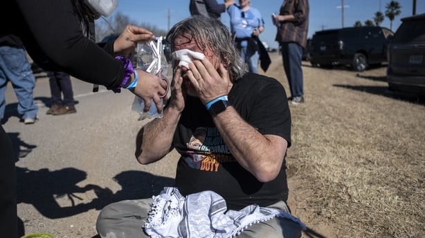 a man wipes his eyes after tear gas was deployed