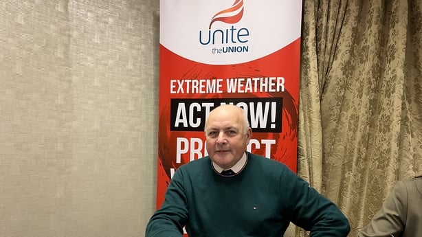 Image of a man with the Unite trade union banner behind him