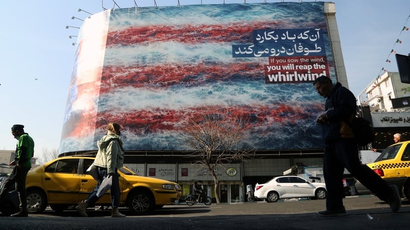 People walk past an anti-American billboard in Tehran yesterday