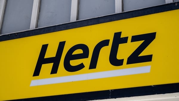 Hertz car rental storefront sign with yellow background