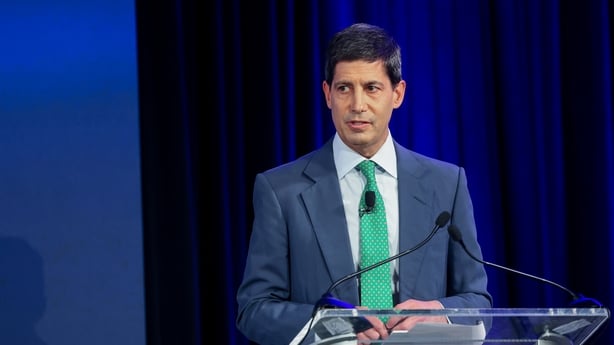 Business man in a suit delivering a speech on a stage