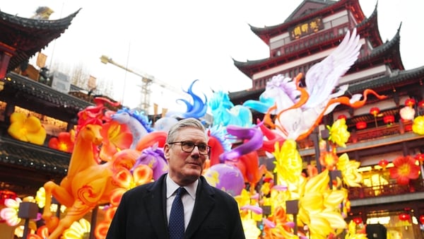 UK Prime Minister Keir Starmer in China with traditiona Chinese houses and dragons in the background