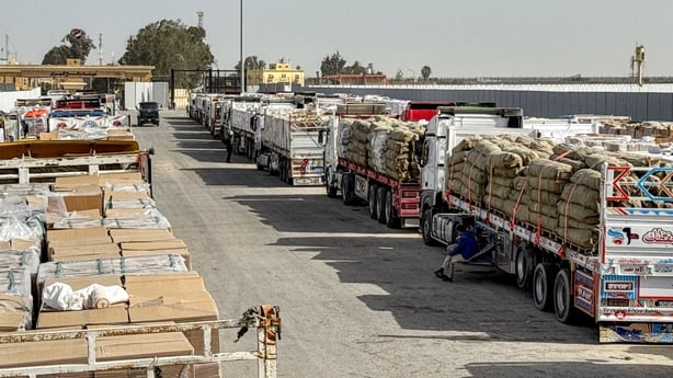 Trucks transporting humanitarian aid wait to enter through the Egyptian side of the Rafah border crossing