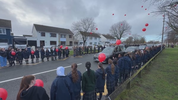 Students form a guard of honour and release red balloons in memory of Grace Lynch