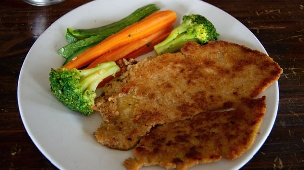 Pork Milanese on a plate with brocolli and carrots