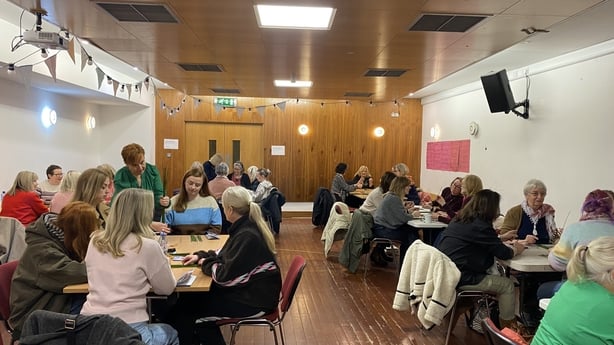 People gathered in a hall for St Brigid cross workshop in Dundalk