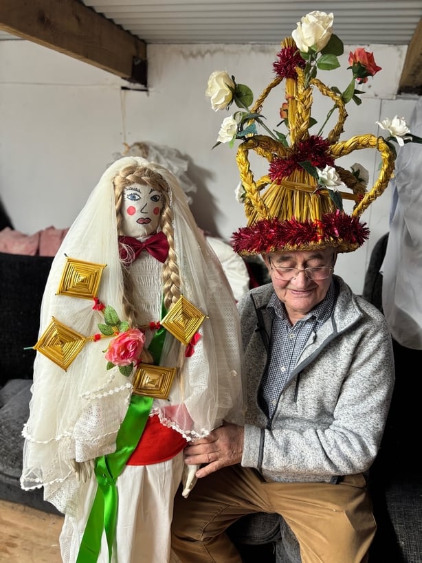 A man wears a straw hat for Kilgobnet Biddy 