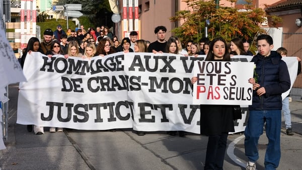 Attendees with a banner reading "tribute to the victims of Crans Montana, justice and truth" take part in a silent march organized in memory of some of the victims of the Crans Montana deadly New Year's Eve fire, in Lutry, near Lausanne, on January 31, 20