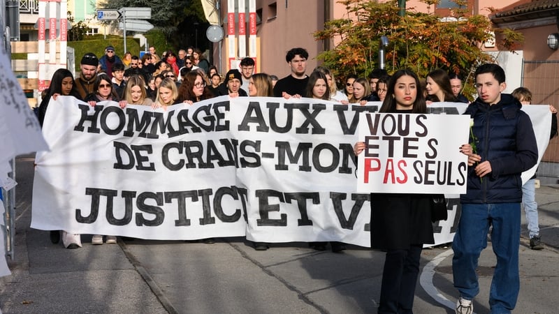 Attendees with a banner reading 'tribute to the victims of Crans Montana, justice and truth' take part in a silent march in Lutry, near Lausanne, organised in memory of some of the victims of the fire