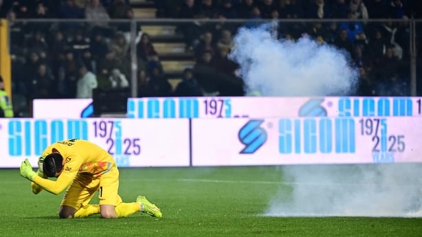 Cremonese's Indonesia goalkeeper #01 Emil Audero reacts as a flare exlodes on the pitch during the Italian Serie A football match between US Cremonese and Inter Milan at the Giovanni Zini Stadium in Cremona, northern Italy, on February 1, 2026
