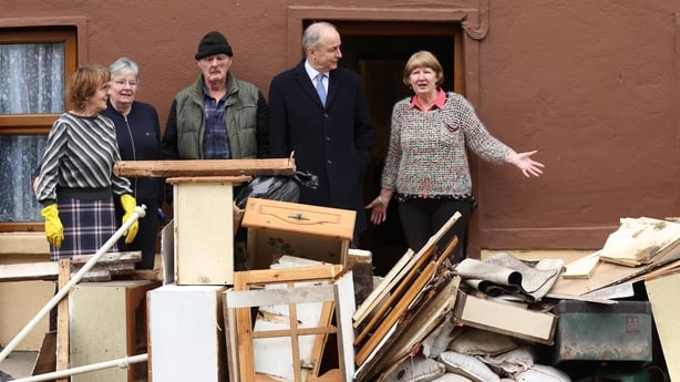 Sarah Thompson piles damaged items thrown out from John McNamara's home following recent flooding on Island Road in County Wexford.