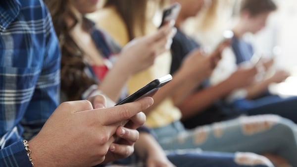 Close Up of a row of young people using mobile phones