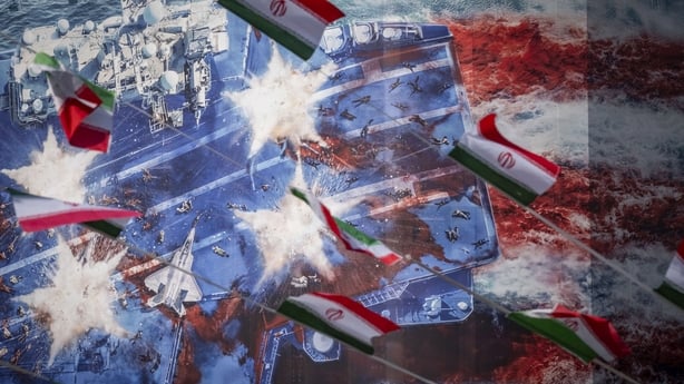 Iranian flags hang in front of a giant anti-U.S. billboard depicting a symbolic image of the destroyed USS Abraham Lincoln (CVN-72) aircraft carrier in downtown Tehran, Iran, on January 28, 2026. (Photo by Morteza Nikoubazl/NurPhoto via Getty Images)