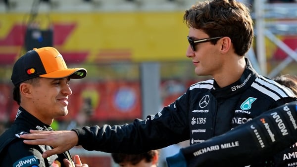 McLaren's British driver Lando Norris and Mercedes' British driver George Russell chat ahead of the Abu Dhabi Formula One Grand Prix at the Yas Marina Circuit in Abu Dhabi on December 7, 2025. (Photo by Andrej ISAKOVIC / AFP)