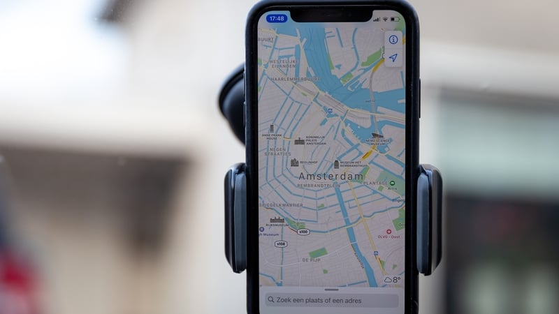 Apple Maps on an phone on the windshield of a car