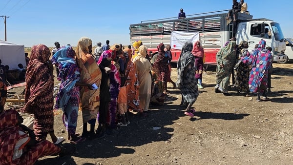 displaced people stand in a queue in Sudan