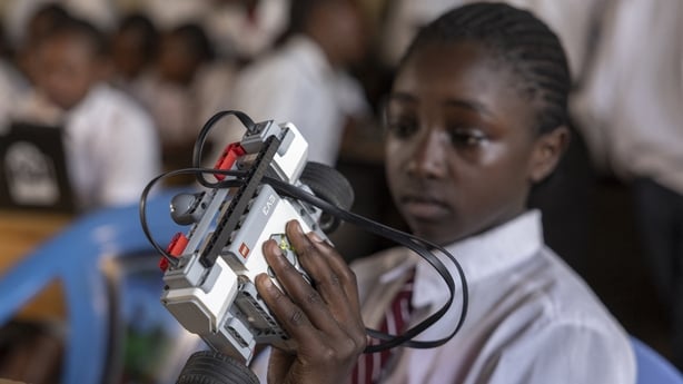 A child works to assemble a small robot 