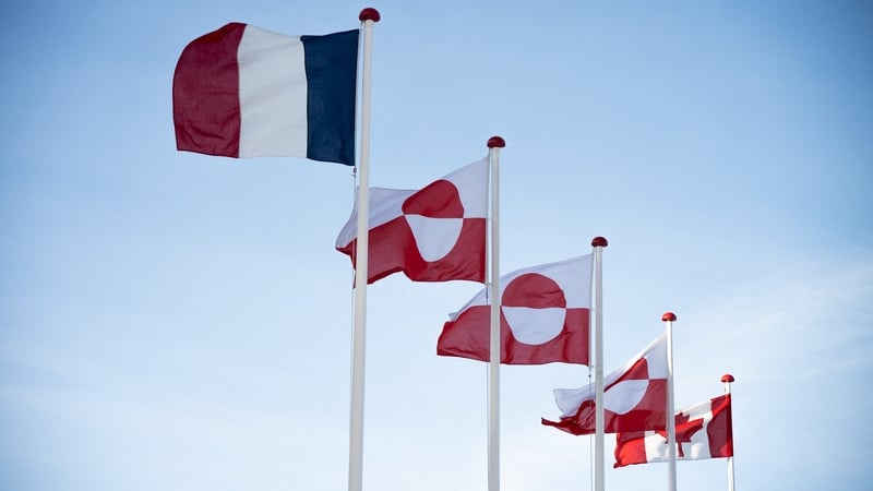 French (L) and Canadian (R) national flags fly alongside Greenlandic ones in front of the Parliament in Nuuk, Greenland