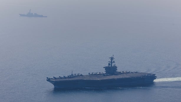 An aerial view of the USS Abraham Lincoln Carrier Strike Group while operating at the Arabian Sea, escorted by two military replenishment ships and two U.S. Coast Guard vessels, as fighter jets from Carrier Air Wing Nine conducted flight operations overhead in the Arabian Sea, on February 6, 2026