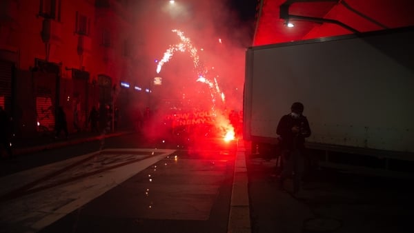 Protesters launch fireworks from behind a banner during the CIO committee protest in Milan
